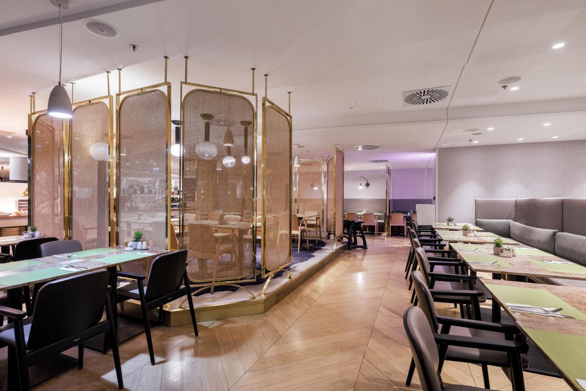 Radisson Blu Resort シフィノウイシチェ エクステリア 写真 The photo depicts a modern restaurant interior. It features a layout with several tables and chairs arranged in an organized manner. There is a decorative partition made of delicate mesh or fabric, providing some privacy between different dining area