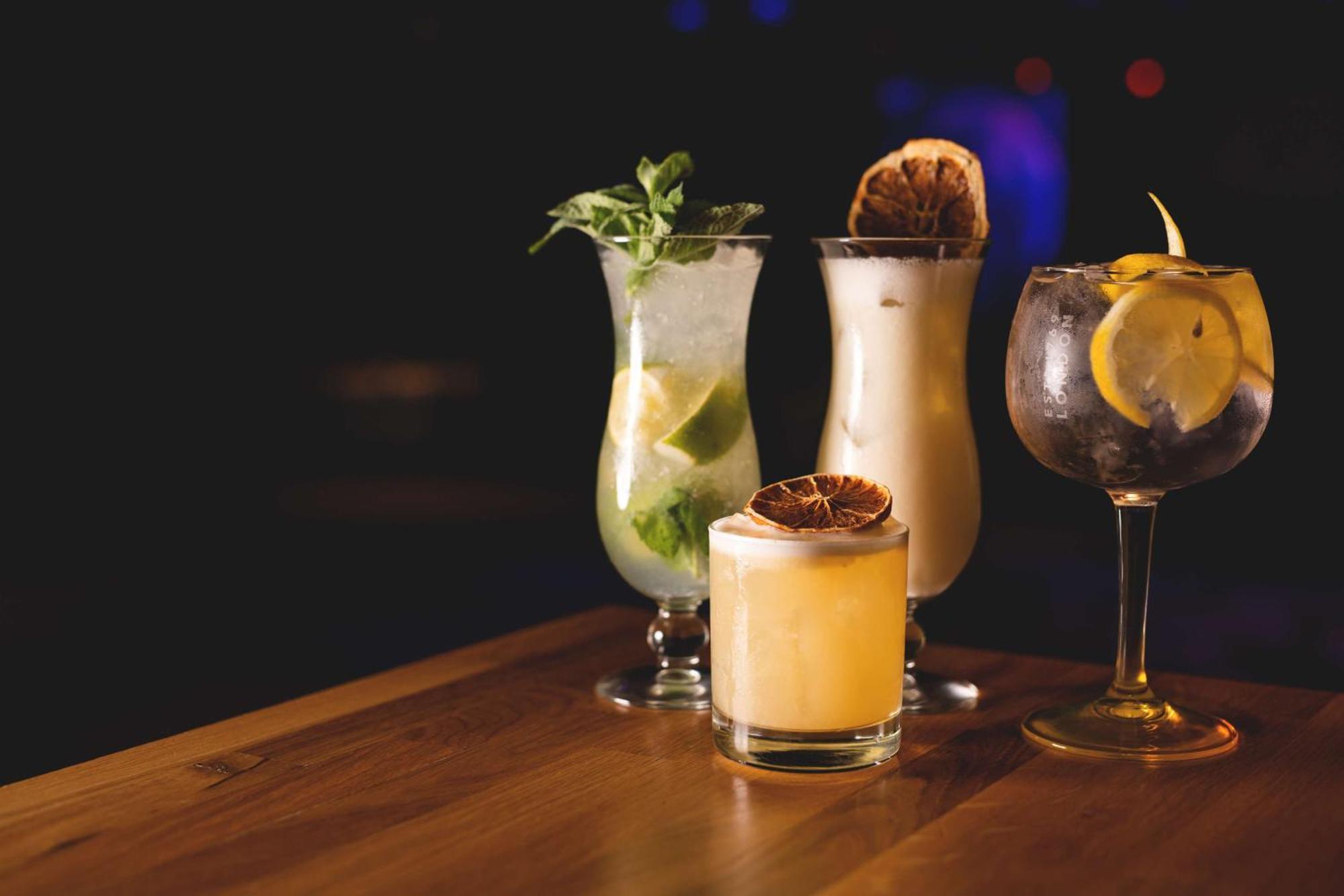 Radisson Blu Resort シフィノウイシチェ エクステリア 写真 The photo showcases a collection of four different cocktails displayed on a wooden table. 

1. **Mojito**: A tall glass filled with lime slices, mint leaves, and a clear liquid, likely rum-based, garnished with fresh mint.
2. **Creamy Cocktail**: A s