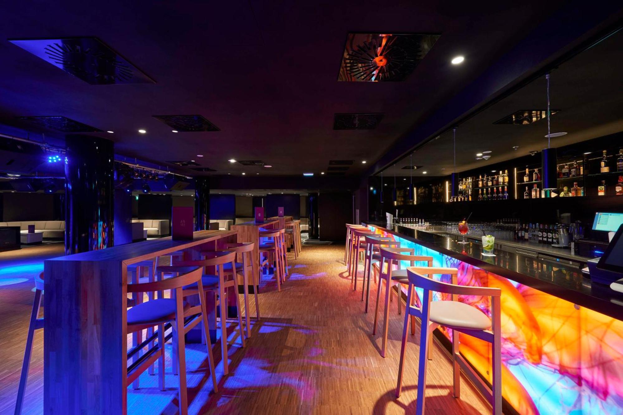 Radisson Blu Resort シフィノウイシチェ エクステリア 写真 The photo depicts a modern bar interior with a sleek and contemporary design. There are high wooden stools positioned along a bar counter, which features vibrant, colorful lighting underneath. The bar area is dimly lit, creating a nightlife ambiance,