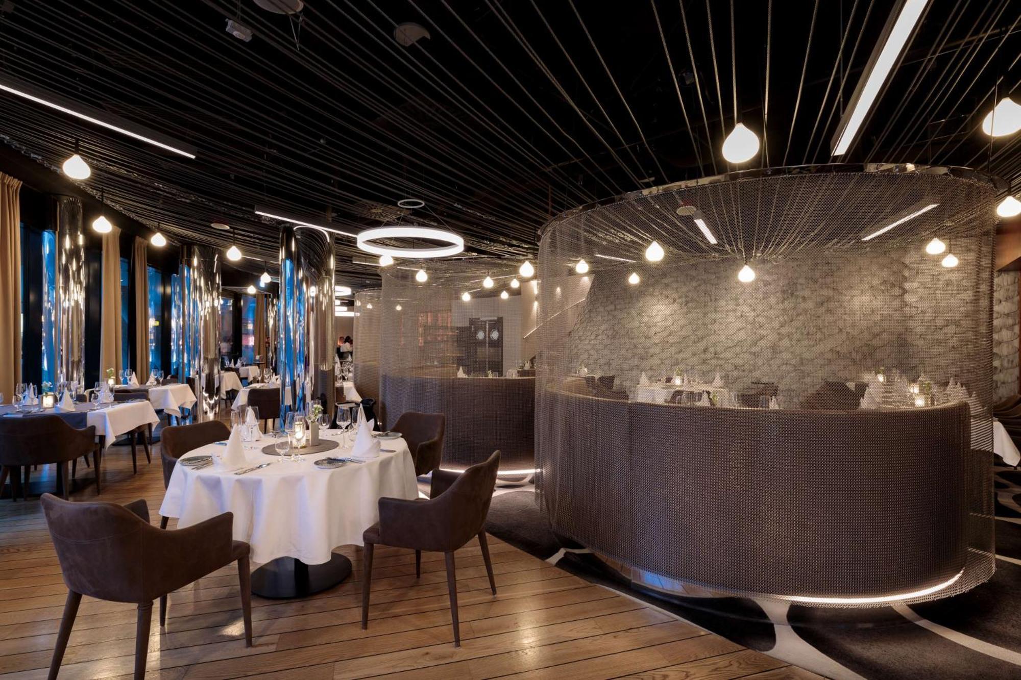 Radisson Blu Resort シフィノウイシチェ エクステリア 写真 The photo shows an elegant restaurant interior. It features polished wooden floors and contemporary decor. Round tables are set with white tablecloths and have chairs arranged around them. The lighting is modern, with multiple pendant lights hanging 